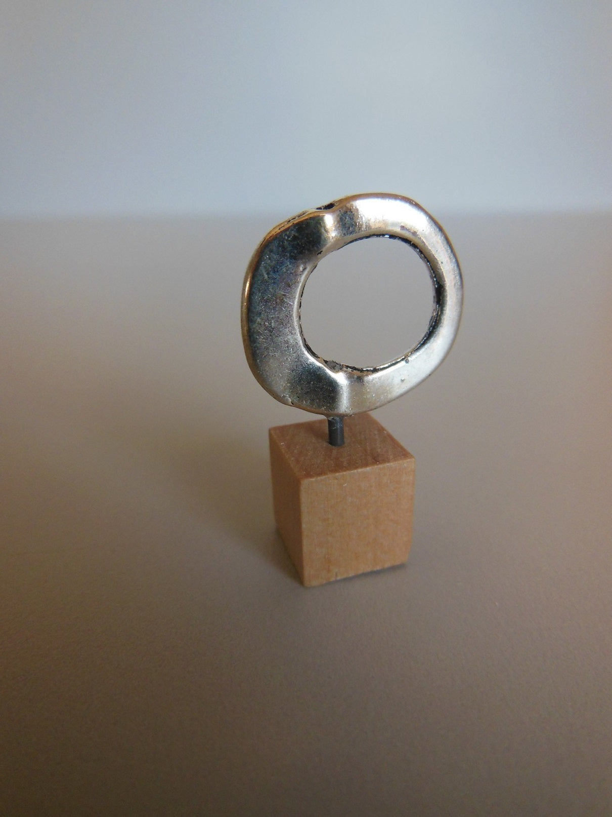 Silver Ring on Wood Base